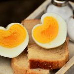 Foto mit zwei Toasthälften mit gekochten Eiern in Herzform.